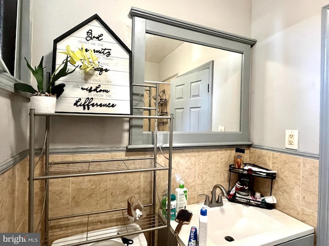 bathroom featuring a wainscoted wall and a sink