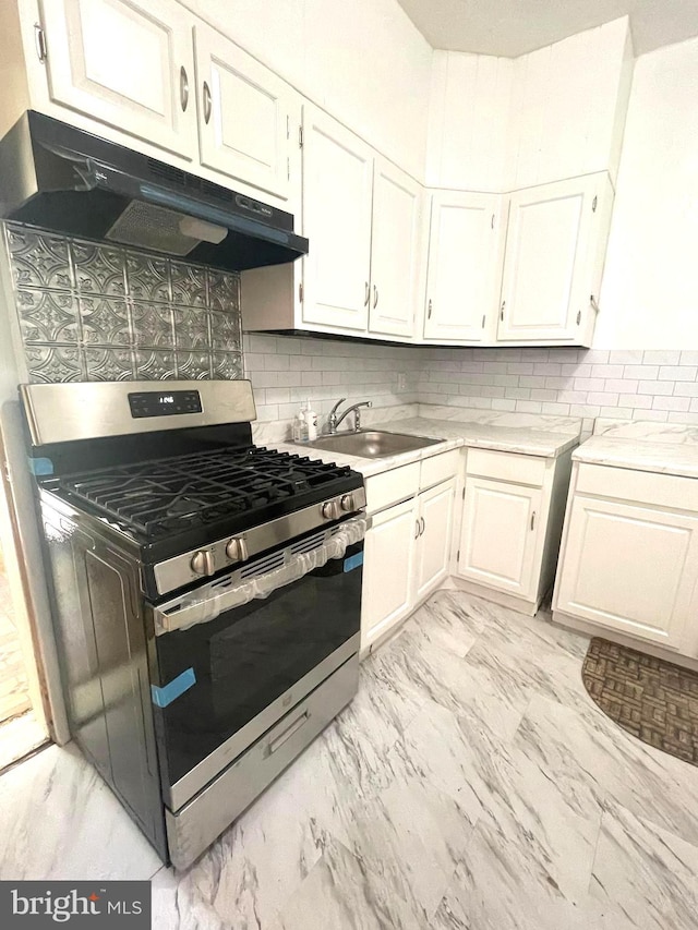 kitchen featuring white cabinetry, tasteful backsplash, stainless steel range with gas cooktop, and sink