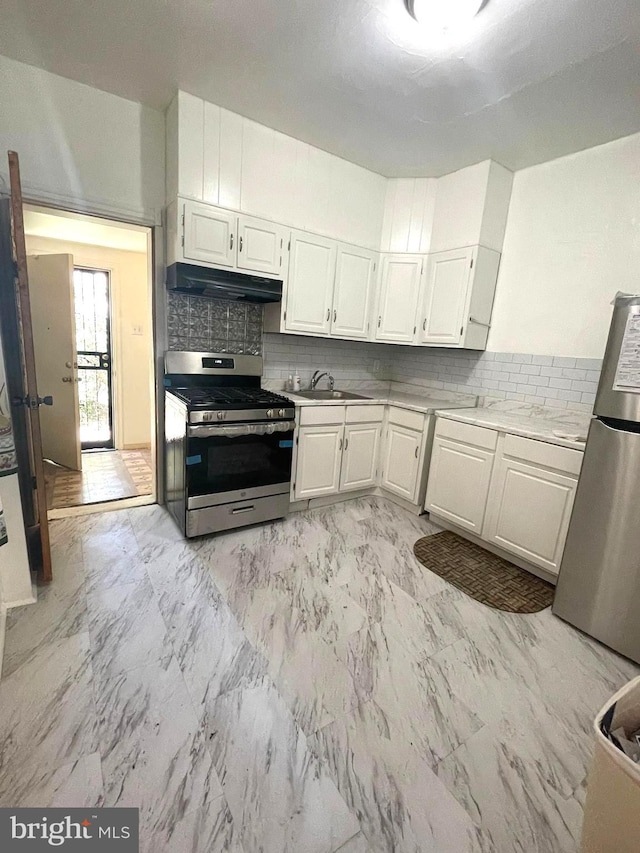 kitchen with white cabinets, stainless steel appliances, backsplash, and sink