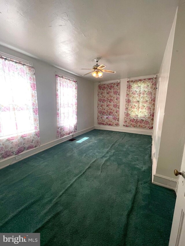 unfurnished room with ceiling fan, carpet flooring, and a textured ceiling