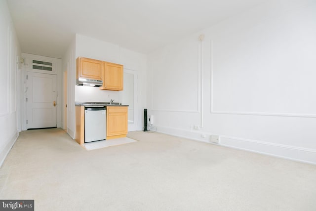 kitchen featuring dishwasher, light brown cabinets, light colored carpet, and sink