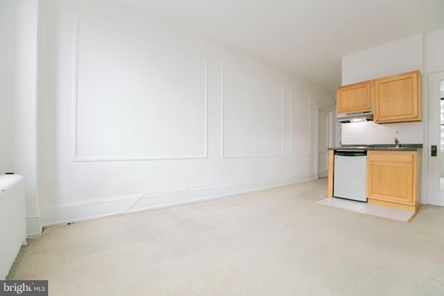 kitchen featuring light carpet, radiator, white dishwasher, sink, and light brown cabinetry