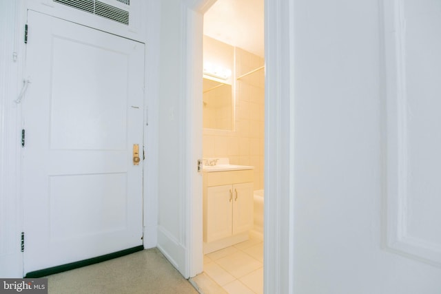 bathroom with tile patterned floors, vanity, and tile walls