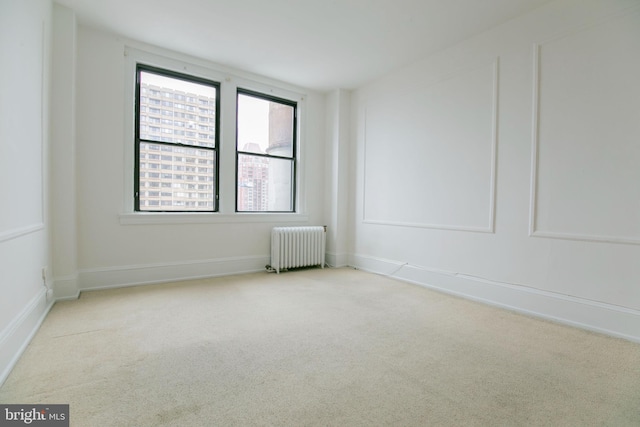 carpeted empty room featuring radiator