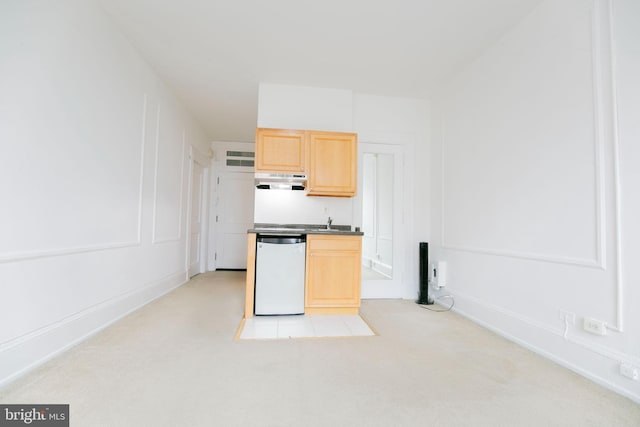 kitchen with dishwasher, light brown cabinets, and light colored carpet