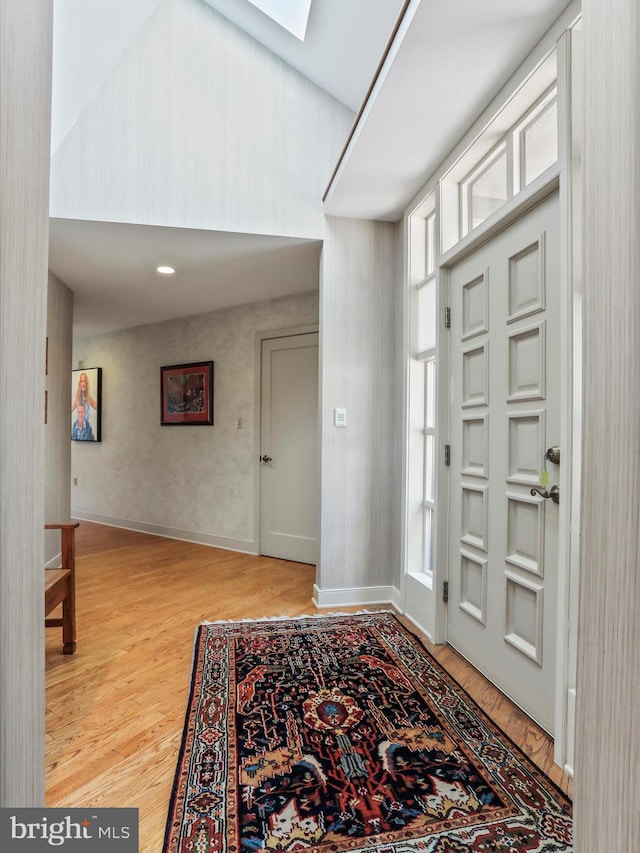 entryway with a skylight and light wood-type flooring