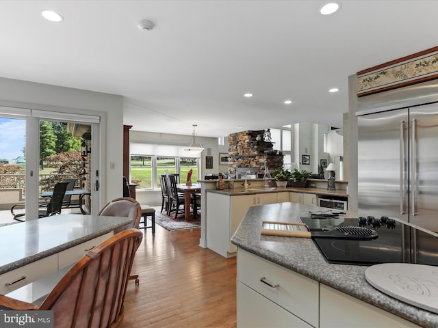 kitchen with pendant lighting, light wood-type flooring, white cabinetry, and plenty of natural light