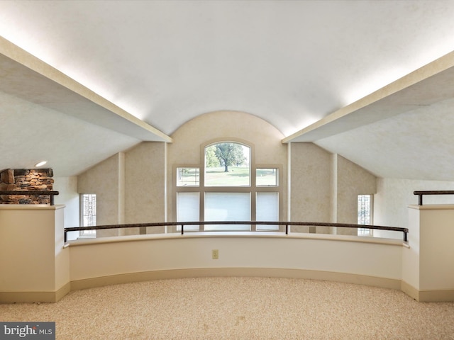 carpeted empty room featuring lofted ceiling