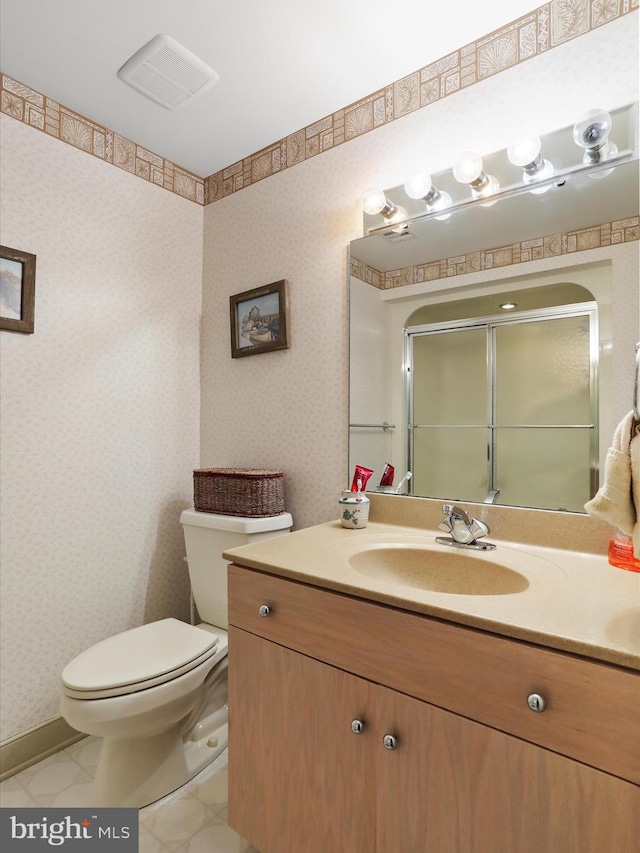 bathroom with walk in shower, vanity, and toilet