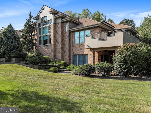 3596 Eagle Dr, Chambersburg, PA 17202 - view of front of home with brick siding, a front yard, a shingled roof, and a balcony