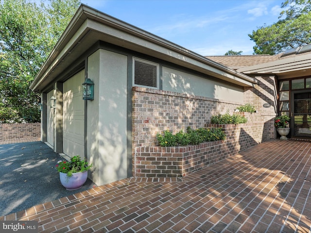 view of property exterior featuring a garage and a patio area