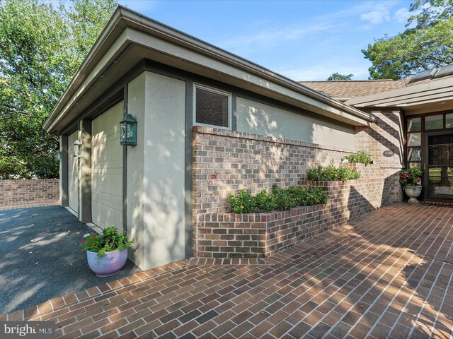 3596 Eagle Dr, Chambersburg, PA 17202 - view of side of property with a garage, aphalt driveway, brick siding, and stucco siding