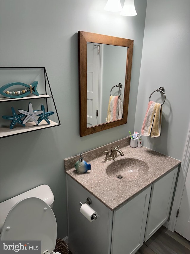 bathroom featuring vanity, toilet, and hardwood / wood-style floors