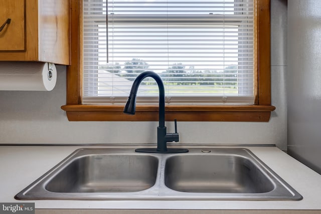 details featuring brown cabinetry, light countertops, and a sink