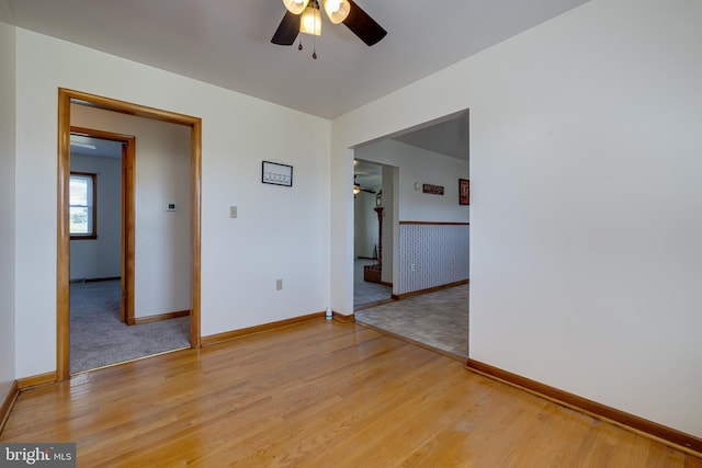 unfurnished room with light wood-style flooring, wallpapered walls, baseboards, and ceiling fan