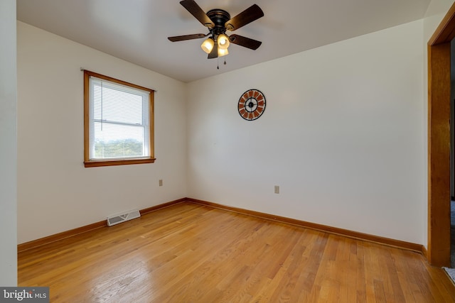 spare room with visible vents, light wood-style flooring, baseboards, and ceiling fan