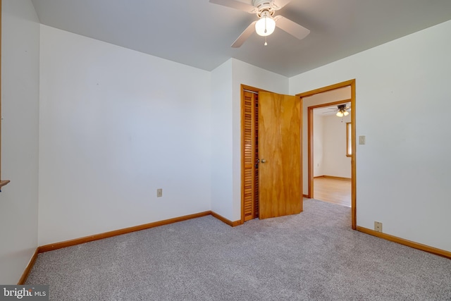 carpeted empty room with baseboards and ceiling fan