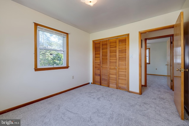 unfurnished bedroom featuring carpet flooring, baseboards, and a closet