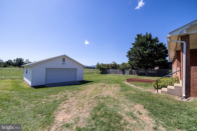 view of yard with an outbuilding, fence, and a detached garage