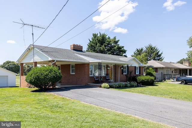 ranch-style home with a porch, a chimney, brick siding, and a front lawn