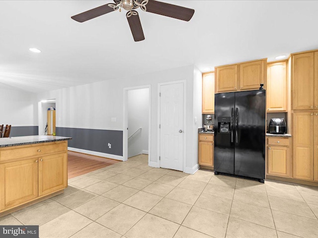 kitchen featuring ceiling fan, light brown cabinetry, black fridge, and light tile patterned floors