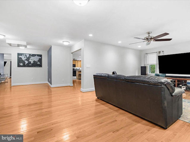 living room featuring light hardwood / wood-style floors and ceiling fan