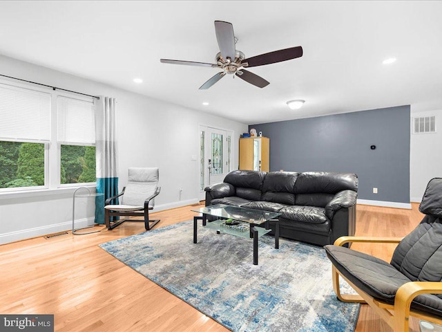 living room featuring wood-type flooring and ceiling fan