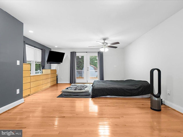 bedroom featuring ceiling fan, light hardwood / wood-style flooring, french doors, and access to exterior