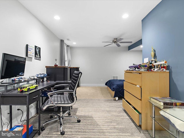 carpeted office space featuring ceiling fan