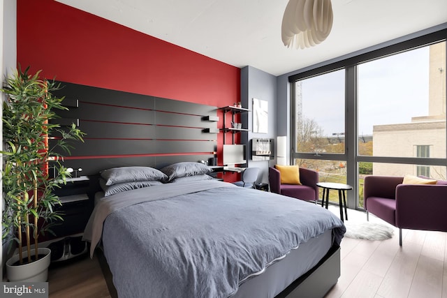 bedroom featuring hardwood / wood-style floors, multiple windows, and expansive windows