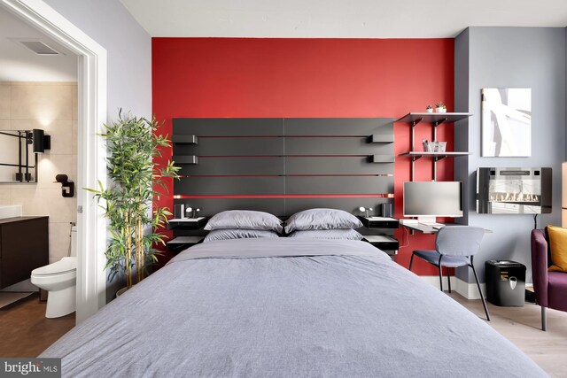 bedroom with concrete flooring and ensuite bathroom