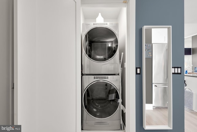 washroom with light wood-type flooring and stacked washer and dryer