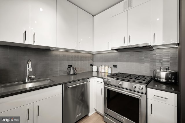 kitchen featuring stainless steel appliances, ventilation hood, backsplash, and white cabinets