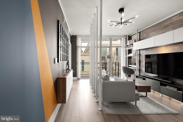 living room with floor to ceiling windows, a notable chandelier, and light hardwood / wood-style flooring