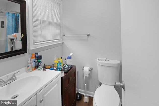 bathroom with toilet, hardwood / wood-style flooring, and vanity