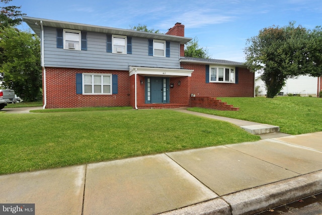 view of front of home with a front yard and cooling unit