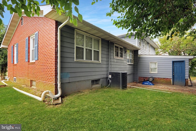 rear view of property with a yard and central AC unit