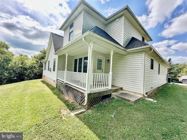 back of property featuring a porch and a lawn