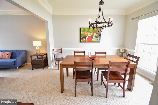 carpeted dining area featuring ornamental molding and an inviting chandelier