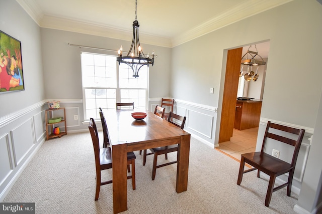 dining space with crown molding, light colored carpet, and an inviting chandelier