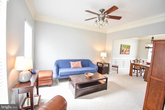 carpeted living room with crown molding and ceiling fan