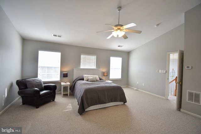 bedroom with vaulted ceiling, light colored carpet, visible vents, and baseboards