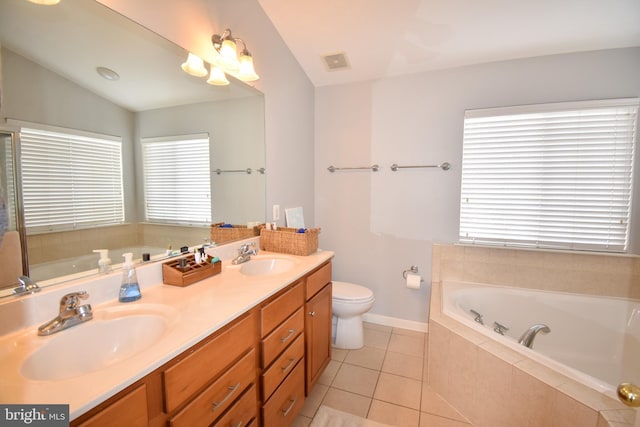 bathroom with toilet, plenty of natural light, tiled bath, and vanity