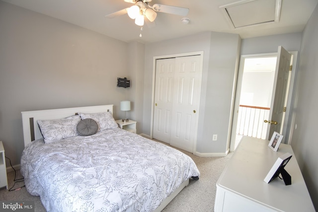 bedroom with baseboards, carpet floors, attic access, ceiling fan, and a closet