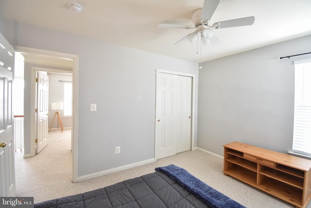 carpeted bedroom with multiple windows, baseboards, and a ceiling fan