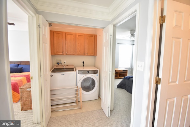 laundry room with a ceiling fan, cabinet space, ornamental molding, light carpet, and independent washer and dryer