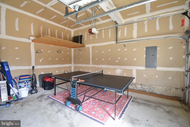 recreation room featuring electric panel, concrete floors, and a garage