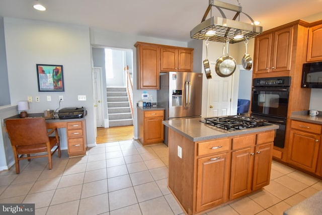 kitchen featuring black appliances, light tile patterned floors, and a kitchen island