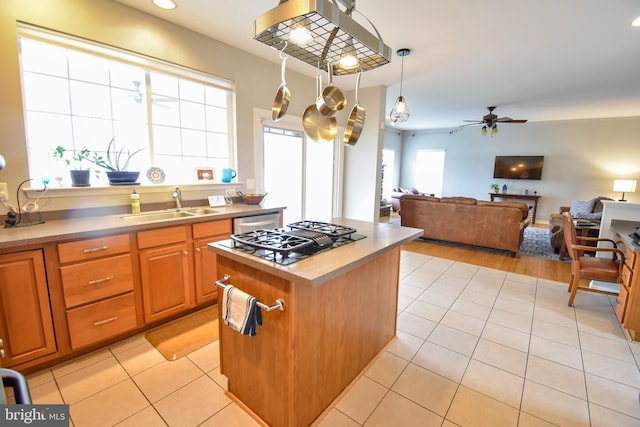 kitchen with a sink, a kitchen island, light tile patterned flooring, stovetop with downdraft, and ceiling fan