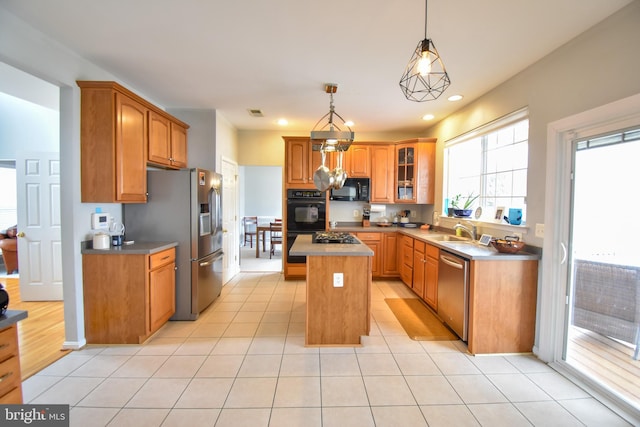 kitchen featuring pendant lighting, light hardwood / wood-style flooring, black appliances, a center island, and sink